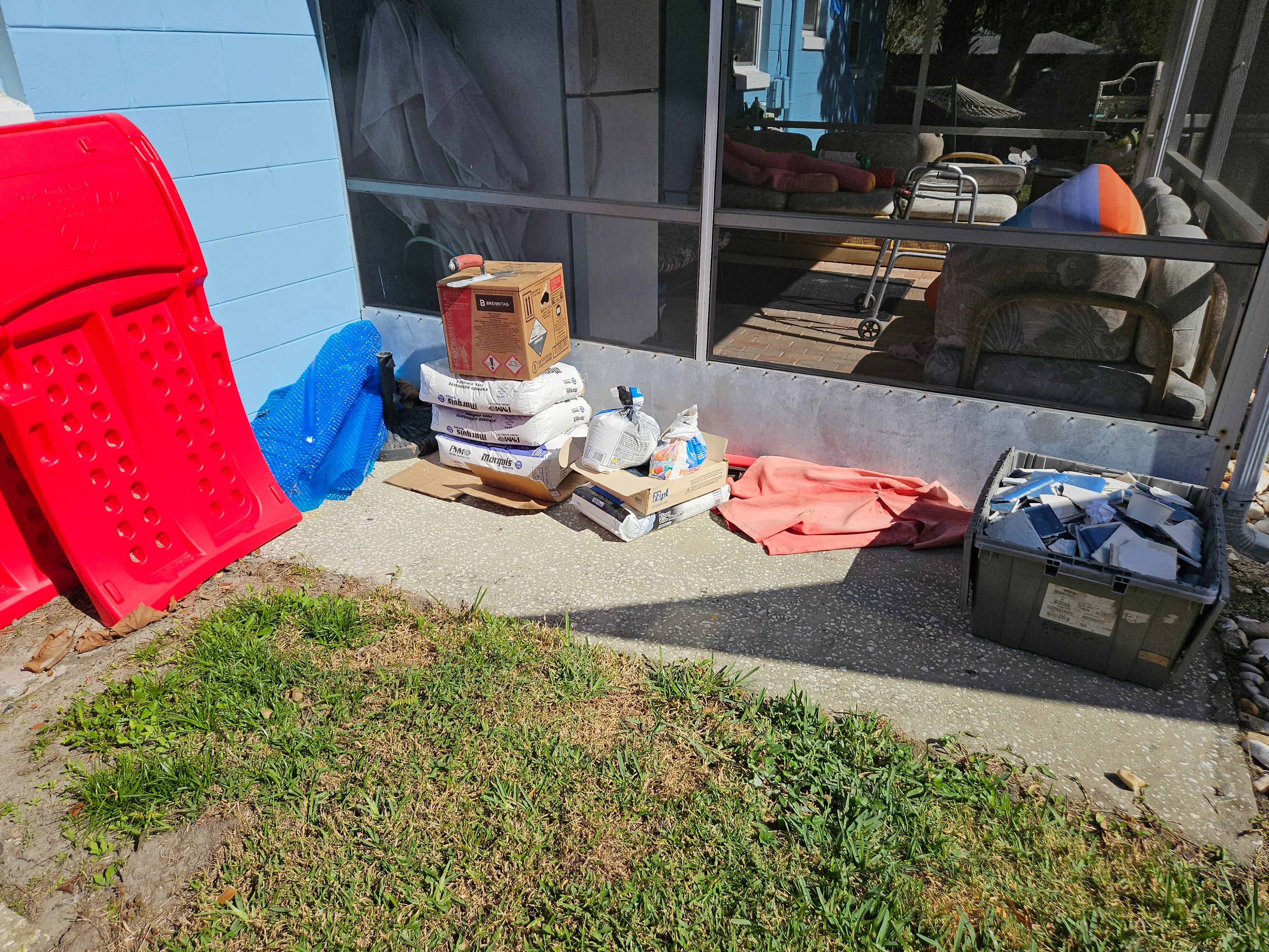 Poolside maintenance supplies including chemical containers, testing kits, and organized storage bins