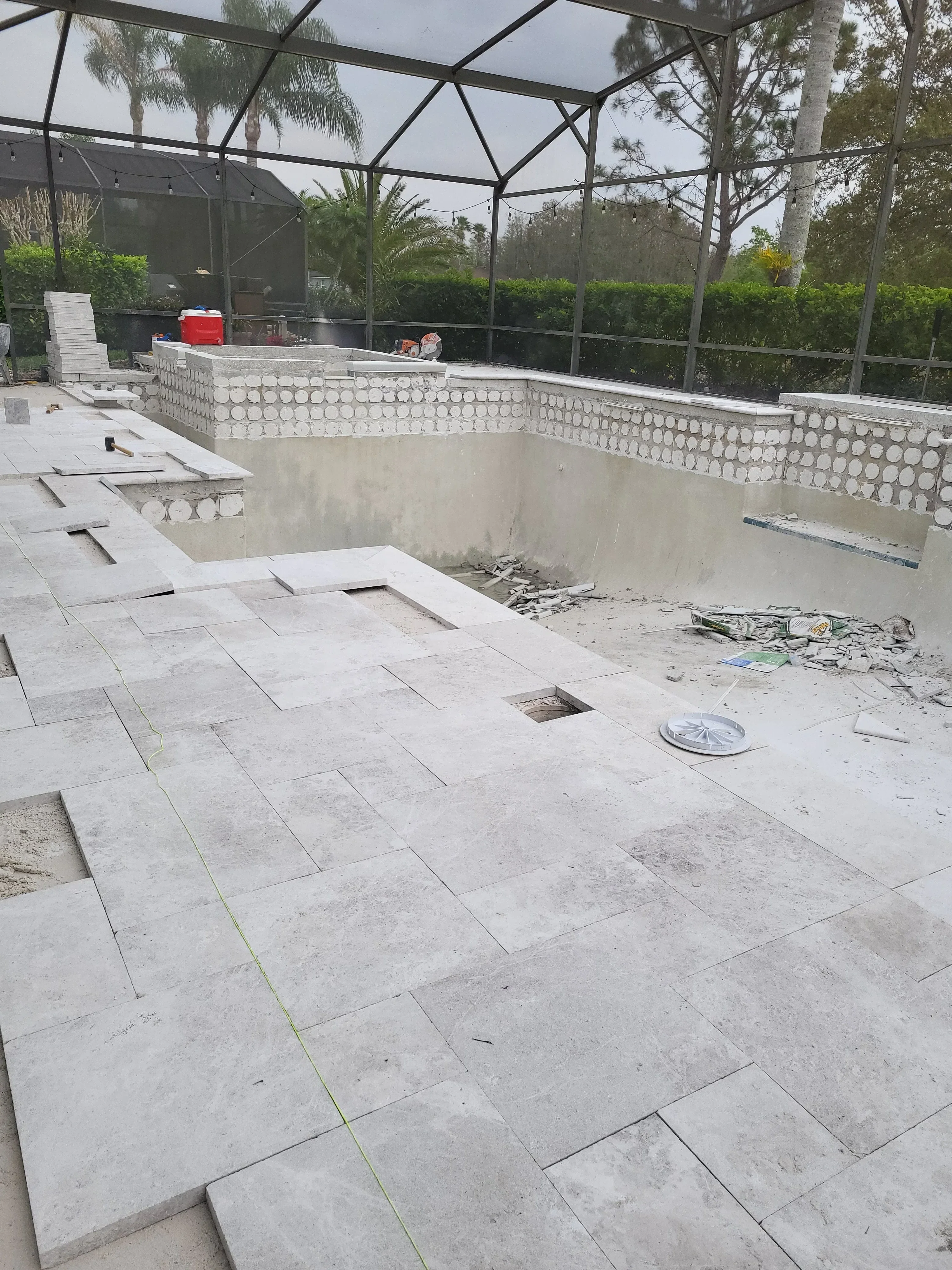 Gray concrete pavers installed in running bond pattern with permeable edging and utility access points