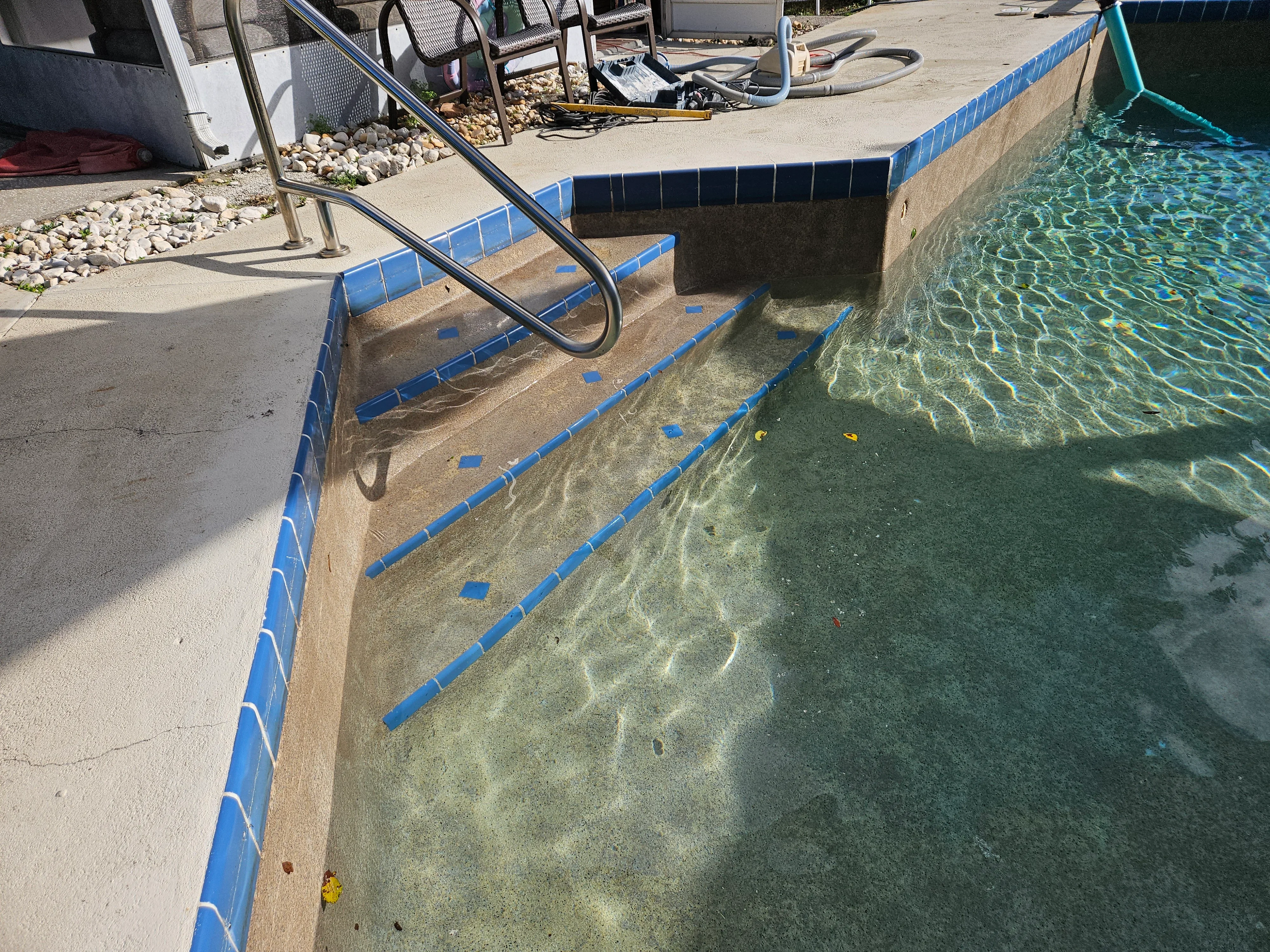 Concrete pool deck with blue safety edging, restored entry stairs, and anti-slip treatment